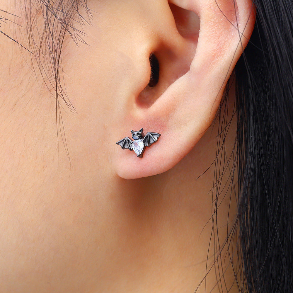 Bat-shaped earring worn on an ear with a close-up view.