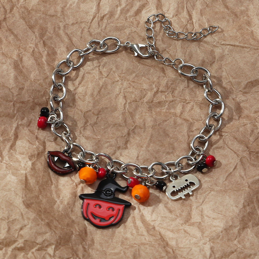 Silver chain bracelet with Halloween-themed charms on a brown paper background