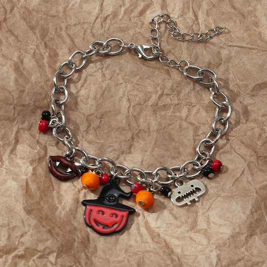 Silver chain bracelet with Halloween-themed charms on a brown paper background