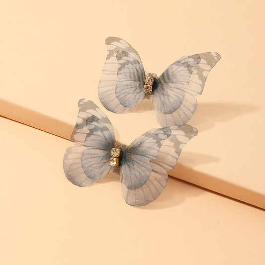 Butterfly-shaped hair clips on a beige background