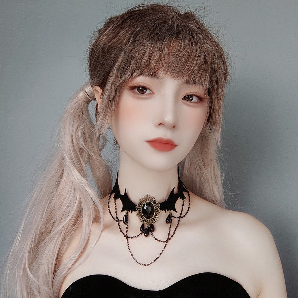 Person with long hair styled in a ponytail wearing a black choker necklace against a gray background