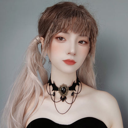 Person with long hair styled in a ponytail wearing a black choker necklace against a gray background