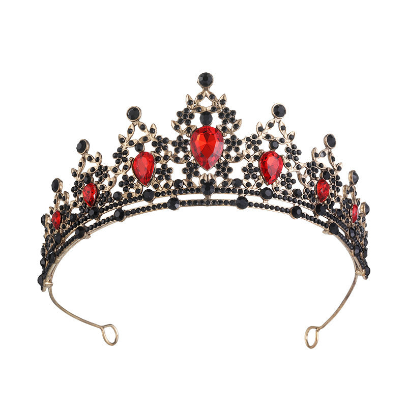 Decorative tiara with red gemstones and gold accents on a white background