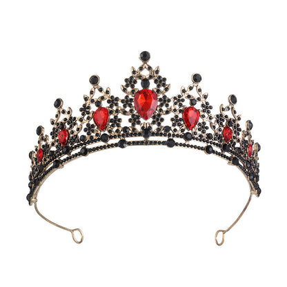 Decorative tiara with red gemstones and gold accents on a white background