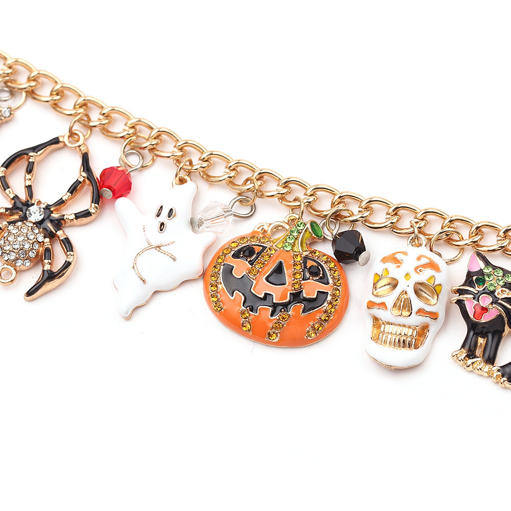 Gold charm bracelet with Halloween-themed charms on a white background