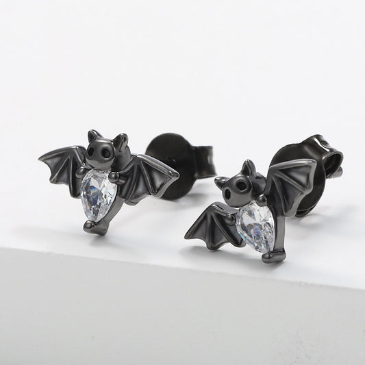 Black bat-shaped earrings with clear gemstones on a light gray background