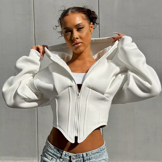 Person wearing a white zip-up hoodie with puffed sleeves against a gray background