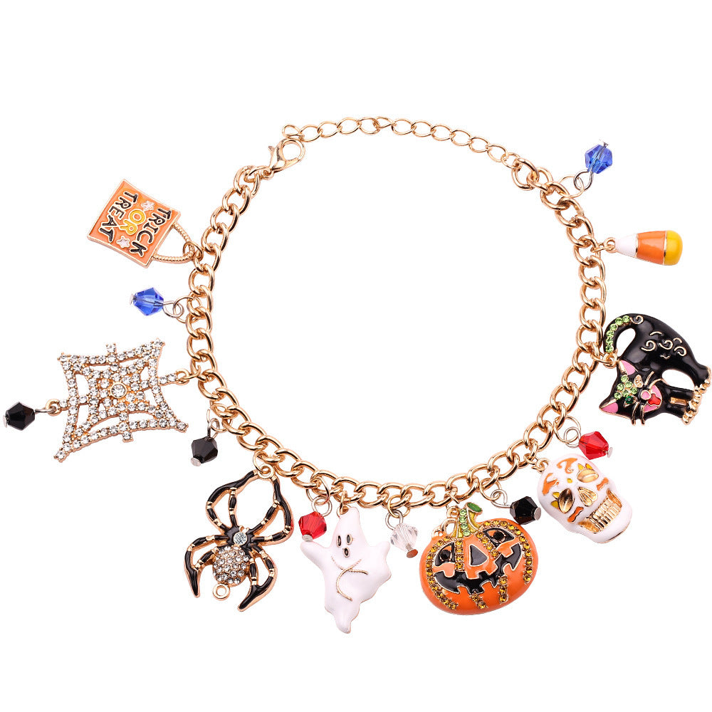 Gold bracelet with Halloween-themed charms on a white background
