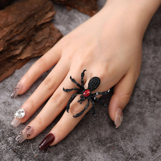 Black spider ring on a hand with a dark background