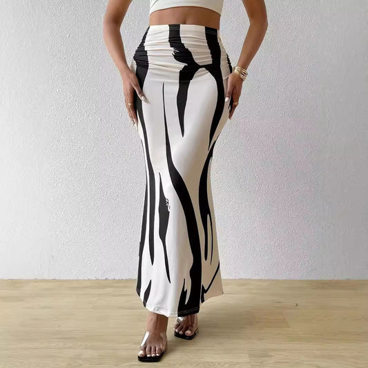 Person wearing black and white patterned pants against a plain background