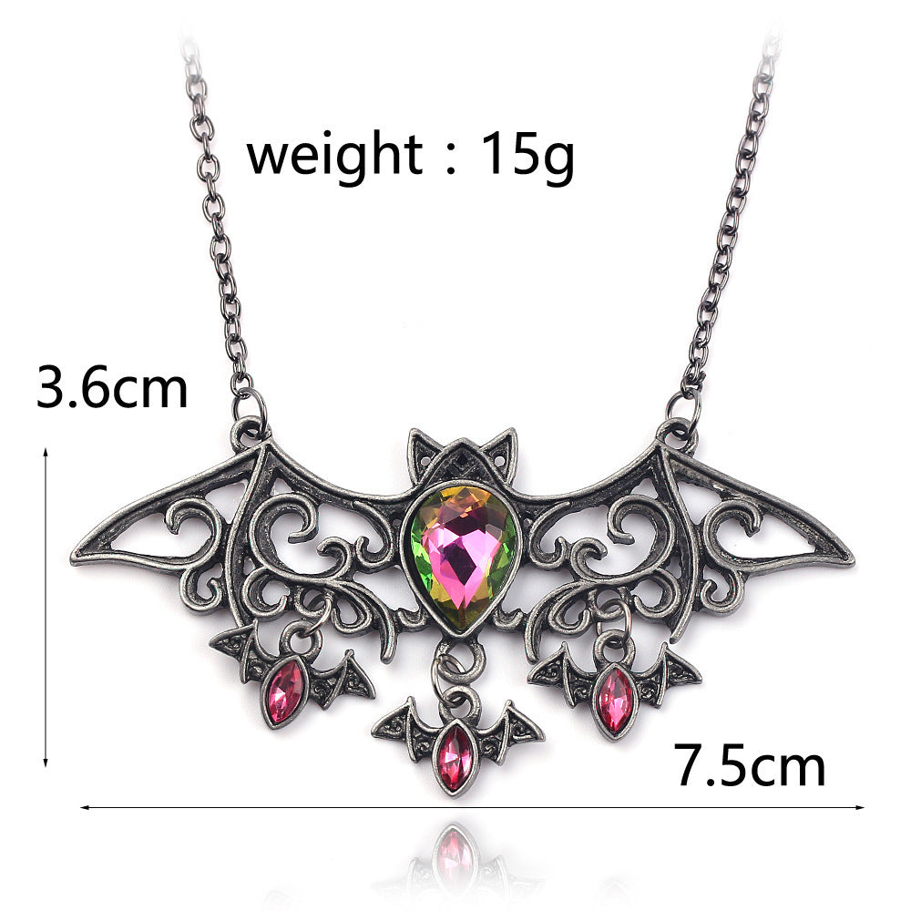 Bat-shaped necklace with gemstones and measurements on a white background