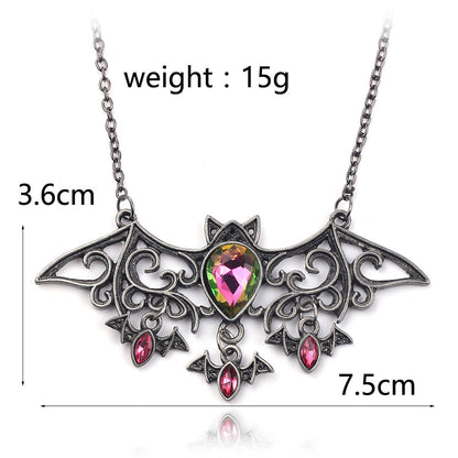 Bat-shaped necklace with gemstones and measurements on a white background