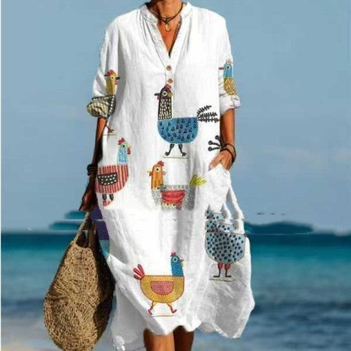 Person wearing a white dress with colorful animal patterns on a beach.