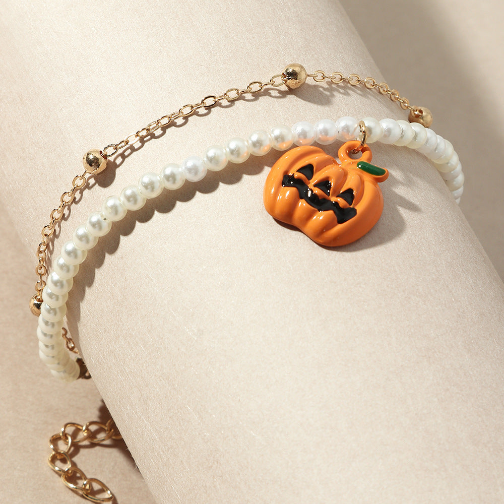 Bracelet with a pumpkin charm on a beige background