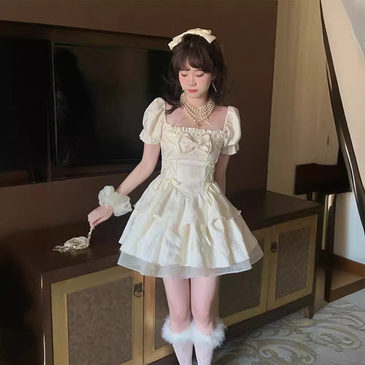 Woman in a white dress with puffed sleeves and bow details in a room.