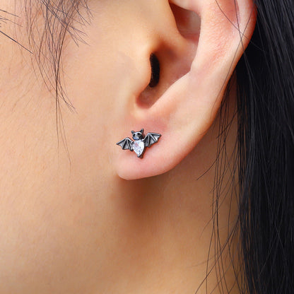 Bat-shaped earring worn on an ear with a close-up view.