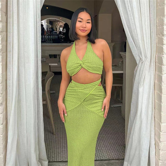 Woman wearing a green dress standing in a doorway.