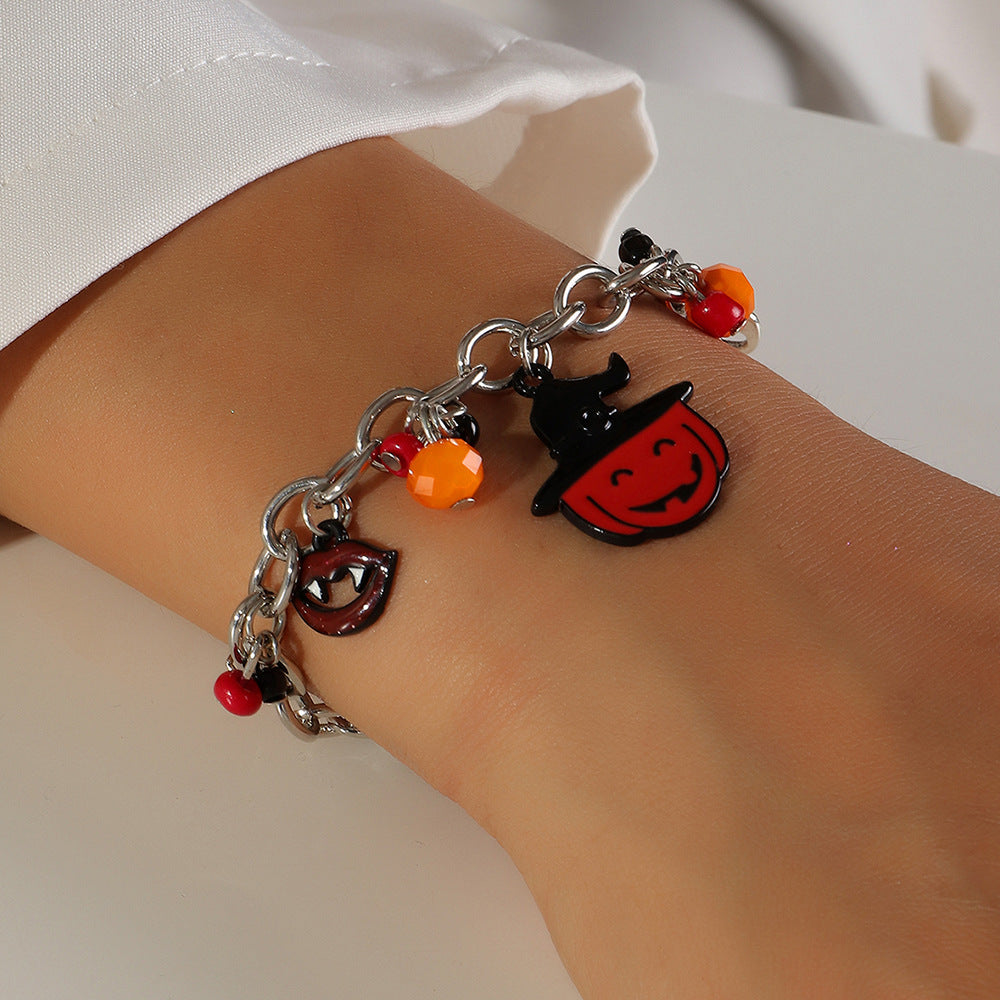 Bracelet with Halloween-themed charms on a wrist against a white background