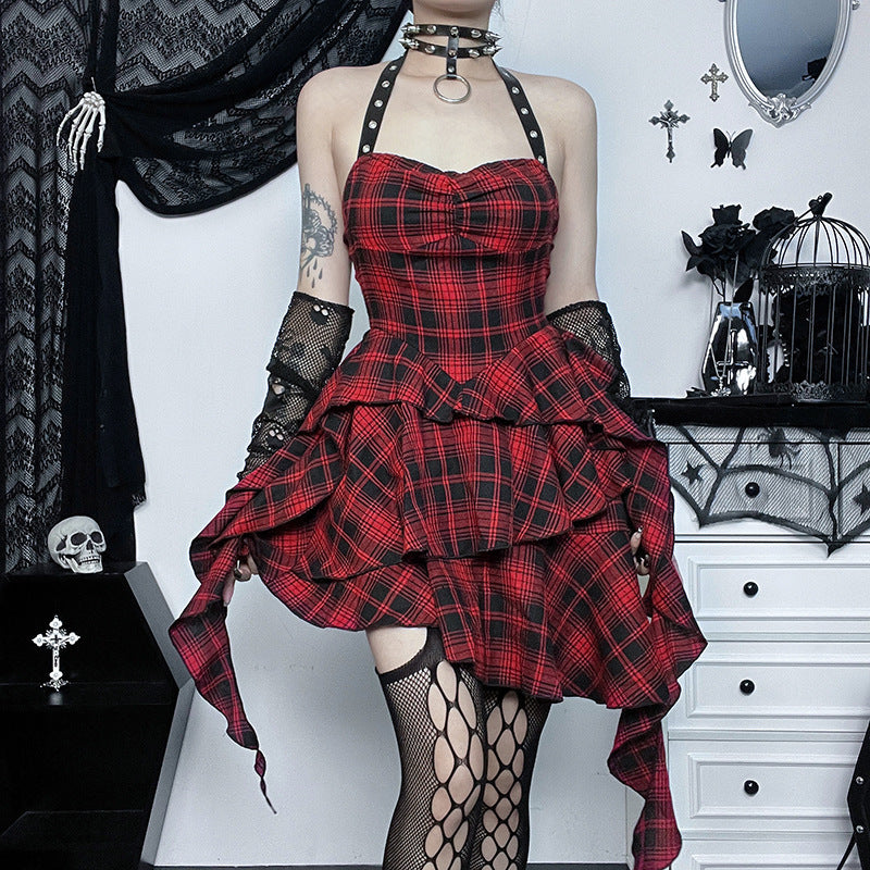 Person wearing a red plaid dress with black accents in a gothic-style room.