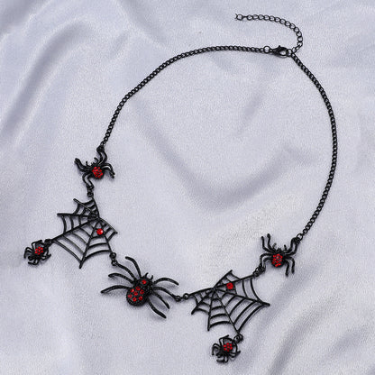 Gothic-style necklace with spider and web designs on a white fabric background